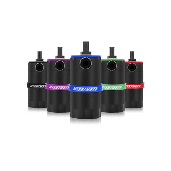 Mishimoto baffled oil catch can in green, featuring a sleek black body, a top inlet, and a colored silicone hose band, surrounded by cans in purple, blue, and red.