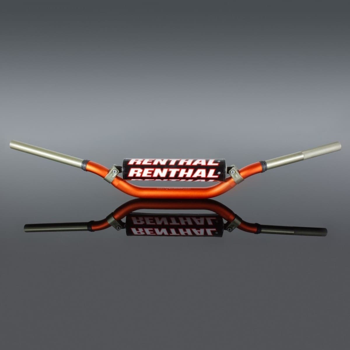Orange Renthal 996 Twinwall handlebars with a distinctive bend, featuring a black and white Renthal logo on the center, and silver aluminum ends, reflecting on a smooth surface.