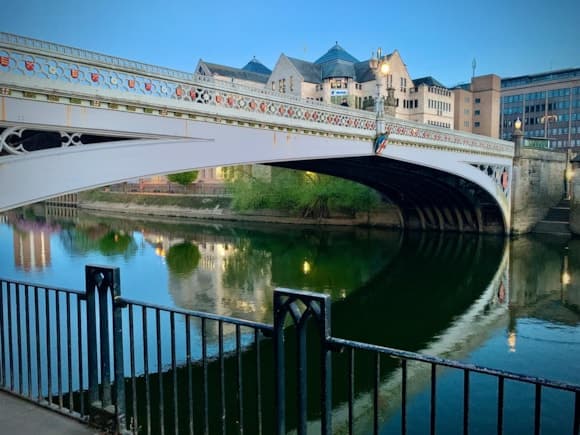 Lendal Bridge arches over the River Ouse, reflecting historic architecture under a serene twilight sky in York.