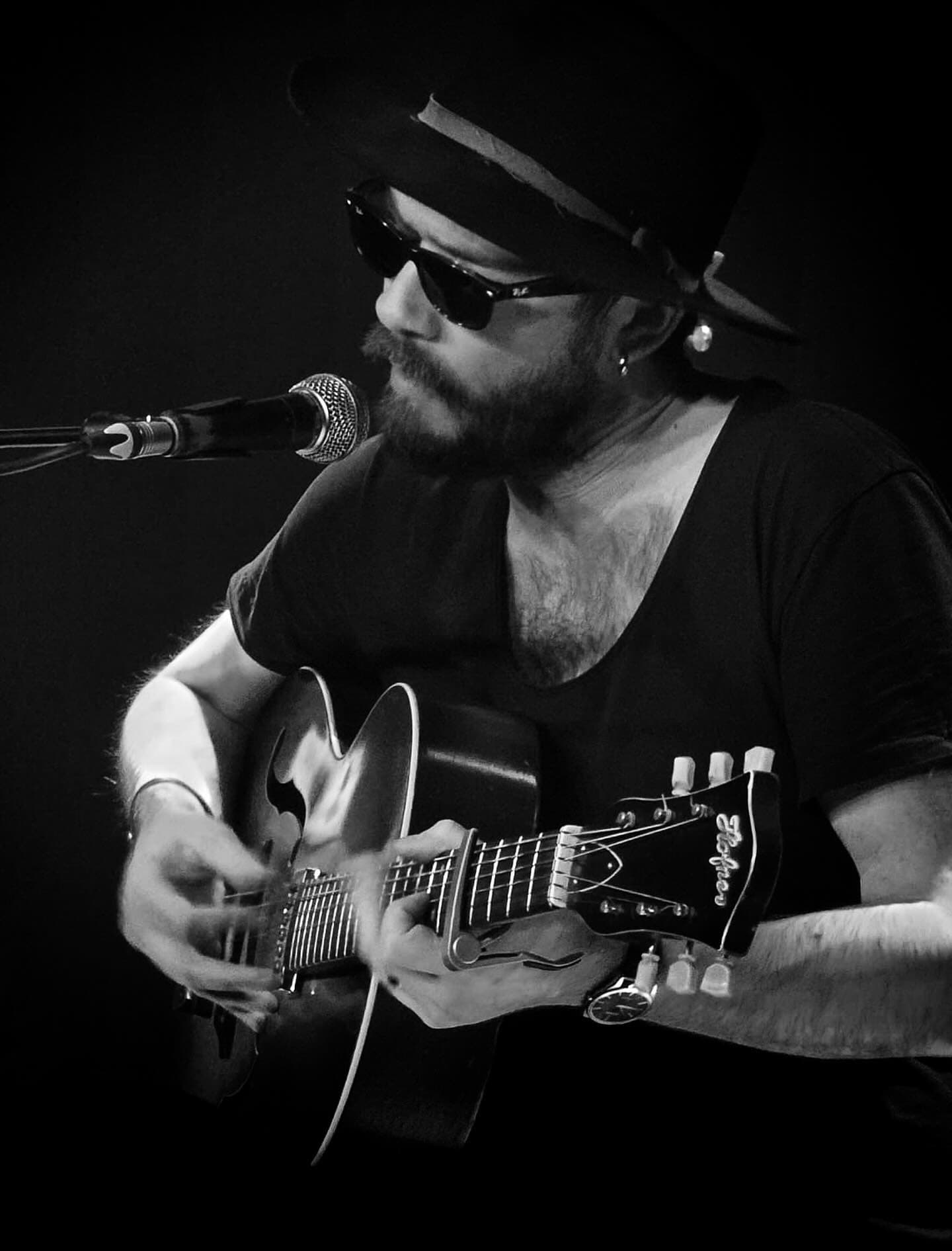 Jack Broadben playing the guitar in black & white