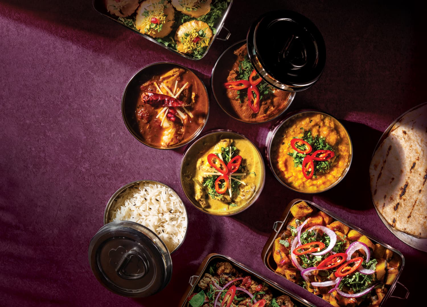 Assorted Yorkshire curries in metal containers with rice