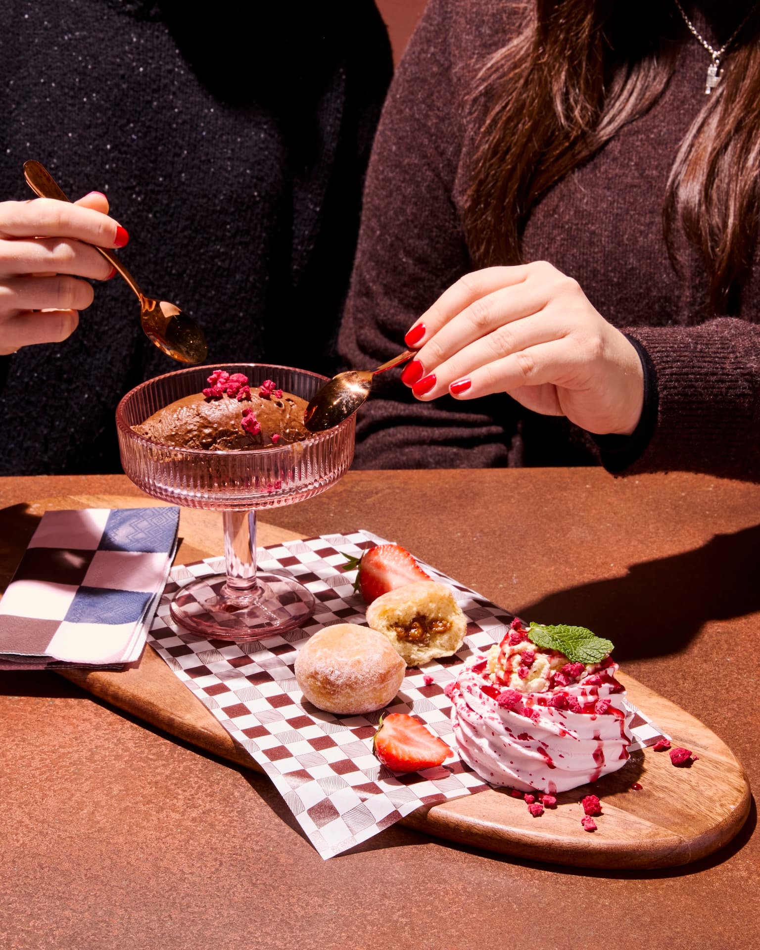Two people enjoying desserts with strawberries and pastries