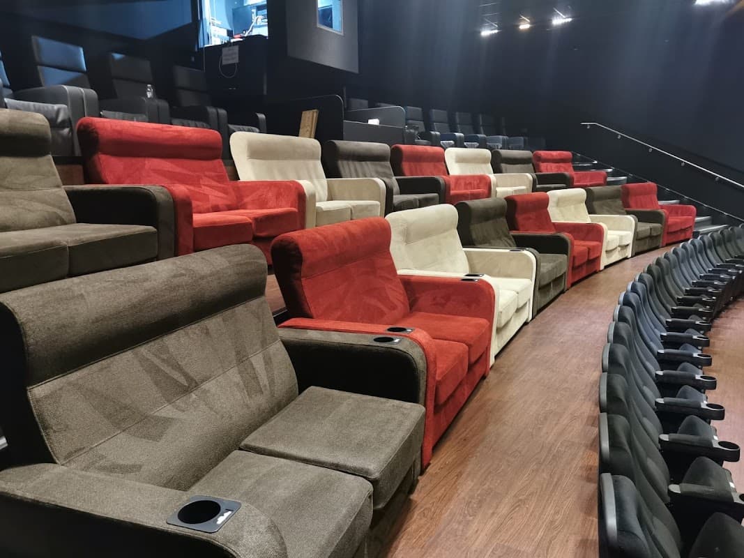 Rows of plush, colorful cinema seats in a modern theater, featuring red, white, and brown upholstery.