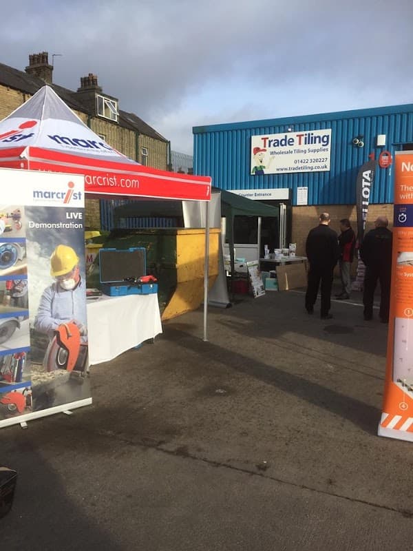 Trade Tiling storefront with vendors, demonstration area, and people interacting outside a blue building in Halifax.