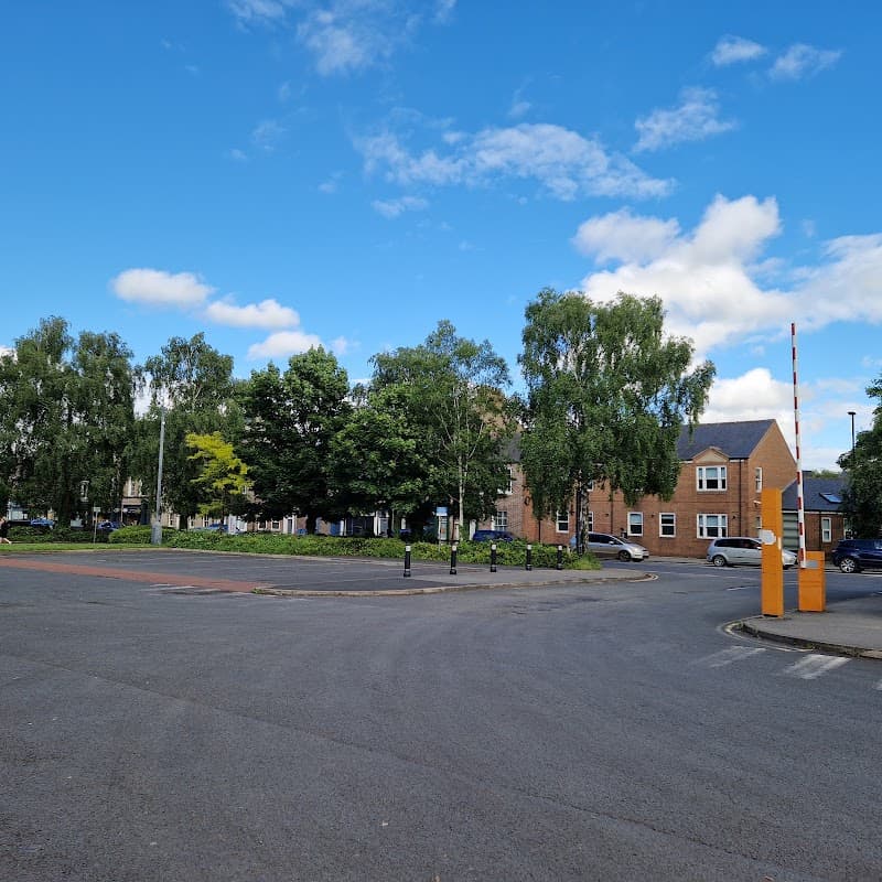 Union Terrace Car Park featuring trees, blue sky, and surrounding buildings with a barrier at the entrance.